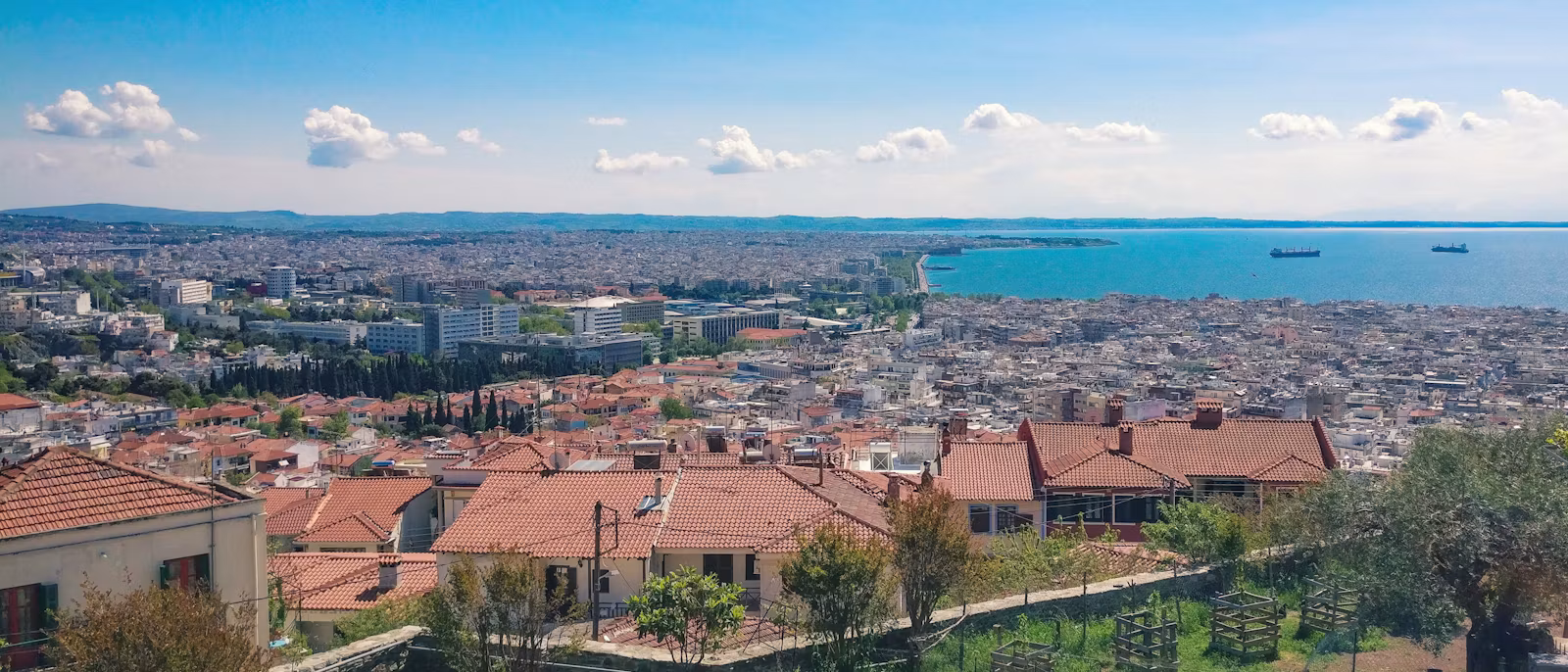 Thessaloniki from the Upper Town: tiled roofs in front, the city running down to the bay and the White Tower waterfront