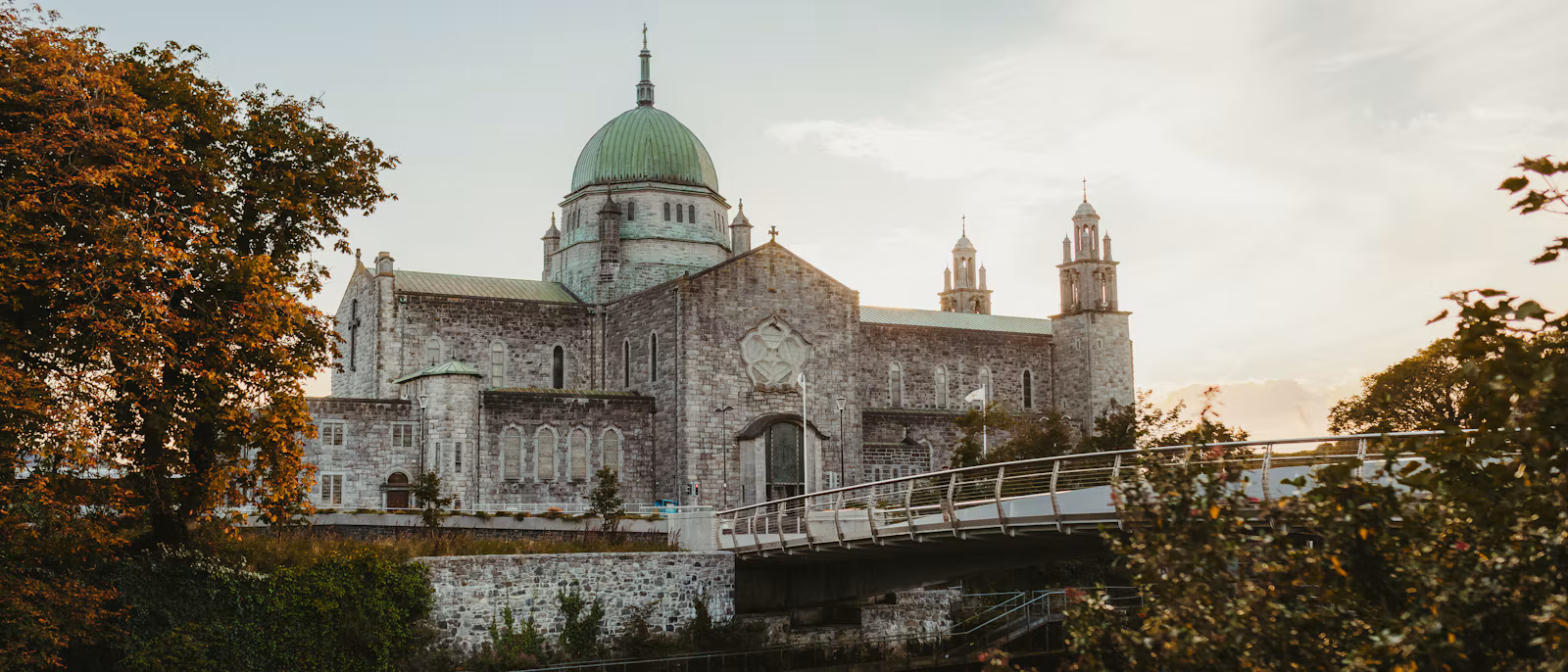 Galway Cathedral's green dome above the River Corrib and the Salmon Weir footbridge