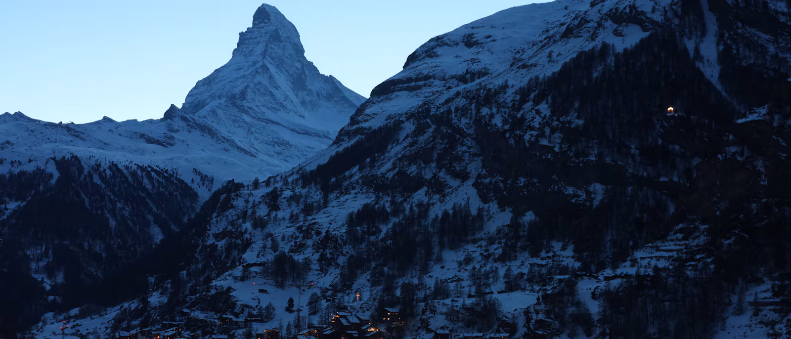 Zermatt's village lights at dusk below the Matterhorn