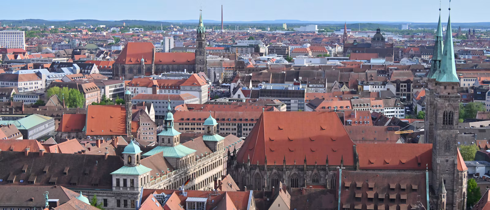 The red roofs of Nuremberg's old town from above, with a twin-spired Gothic church on the right
